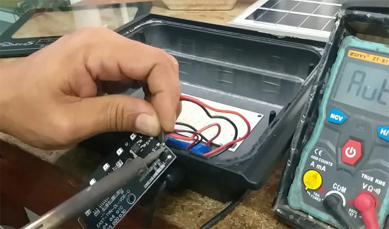 Gỡ mối hàn dây nối từ pin cũ với bảng mạch đèn